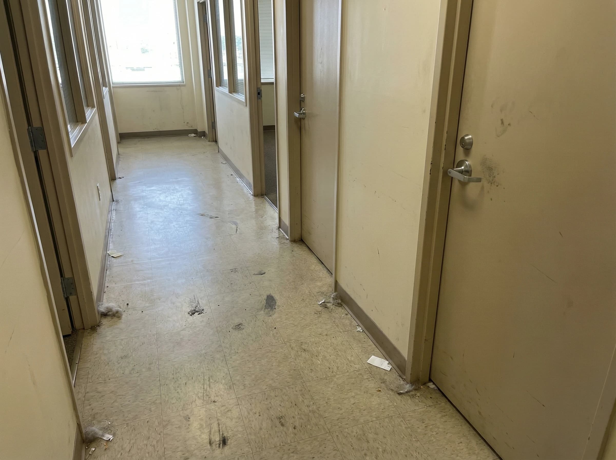 Dirty hallway floor with debris and smudges before professional cleaning